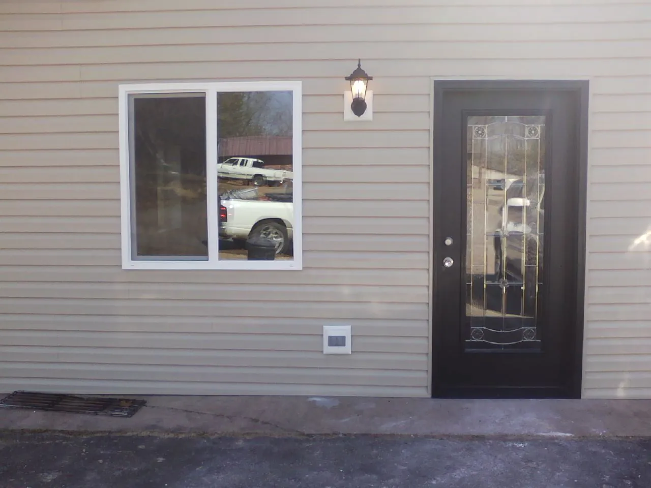 New siding, window and entry door on the side of an addition in Norway