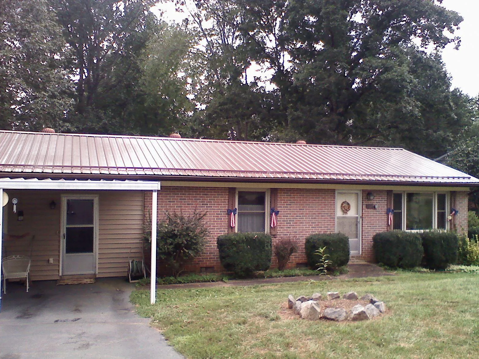 Bronze metal roof and carport on a brick ranch home — Roof Repair work by our crew in Norway